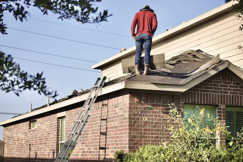 Professional roofer working on a residential roof in Nichols